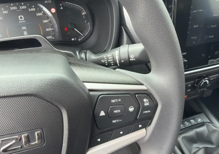 Gros plan sur le volant multifonctions et tableau de bord du pick-up Isuzu D-MAX 2026, intérieur noir.