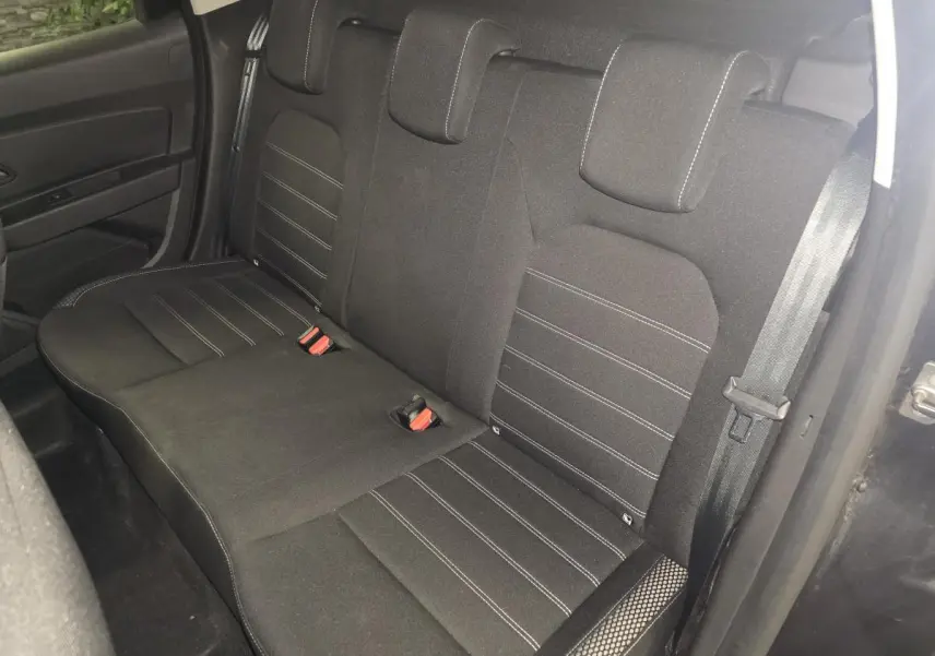 Vue intérieure du siège arrière tissu noir avec surpiqûres blanches du Dacia Duster 2019 côté droit ouvert.