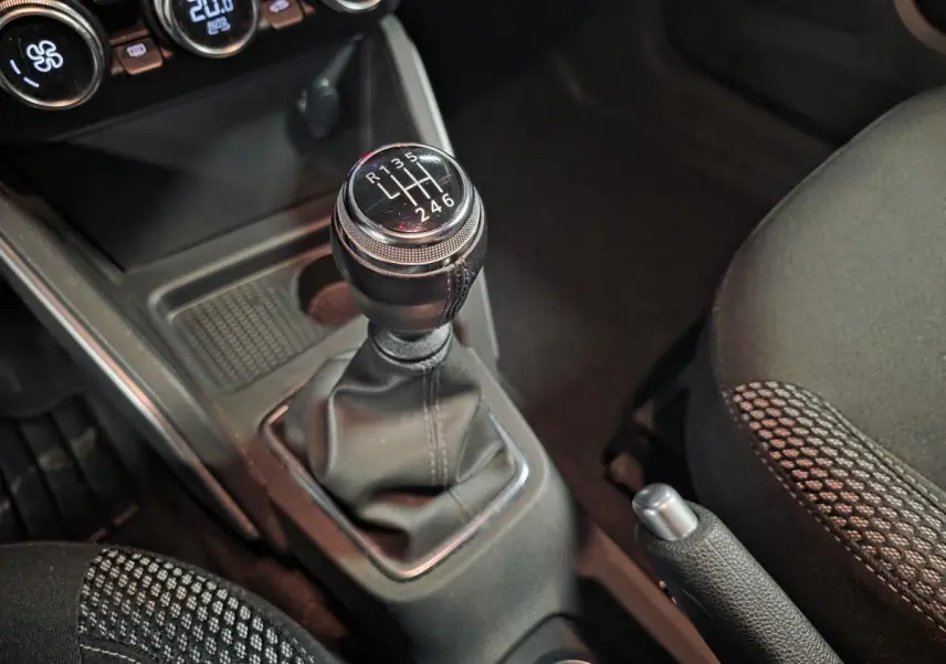 Gros plan sur le levier de vitesses manuel et frein à main du Dacia Duster 1.3 TCe 130 Prestige, intérieur noir.