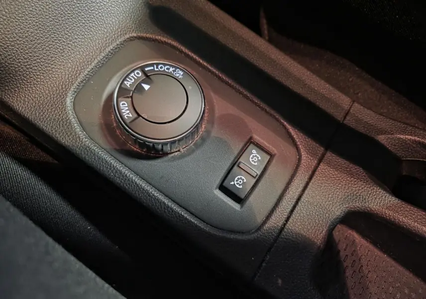 Gros plan sur la molette de sélection 4x4 et les boutons de régulateur de vitesse du Dacia Duster 1.3 TCe noir.