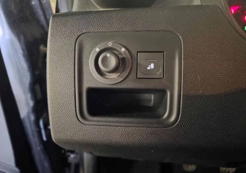 Gros plan sur le tableau de bord côté gauche du Dacia Duster noir 2019, bouton réglage des rétroviseurs et ouverture du coffre.