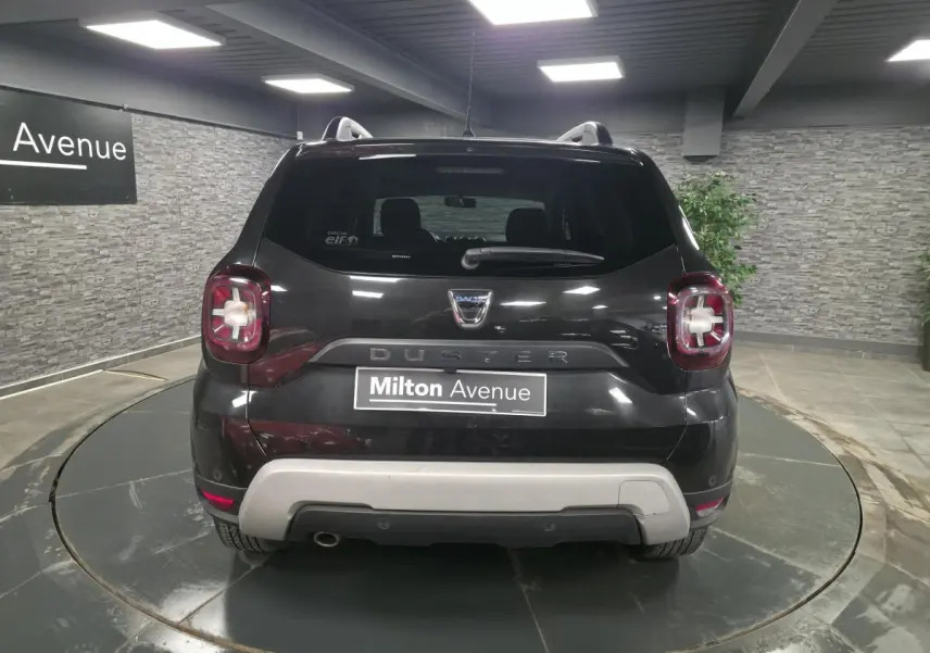 Vue arrière d'un Dacia Duster noir nacré 2019 avec bouclier arrière gris et feux distinctifs en intérieur rouge.