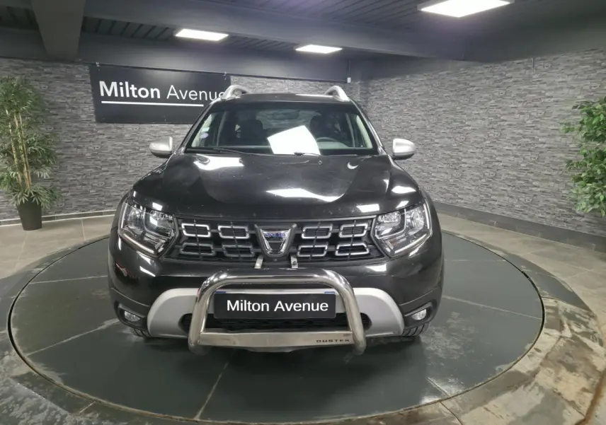 Vue avant d'un Dacia Duster noir nacré 2019 avec calandre chromée et protection de pare-chocs en métal.