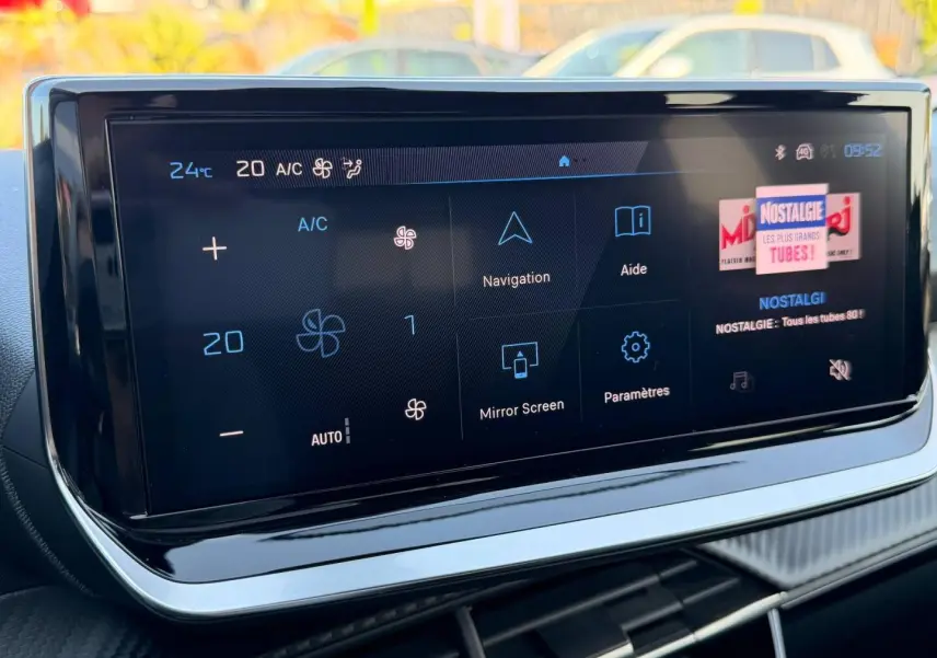 Écran tactile multifonction affichant la climatisation et la navigation dans un Peugeot 208 gris Selenium.