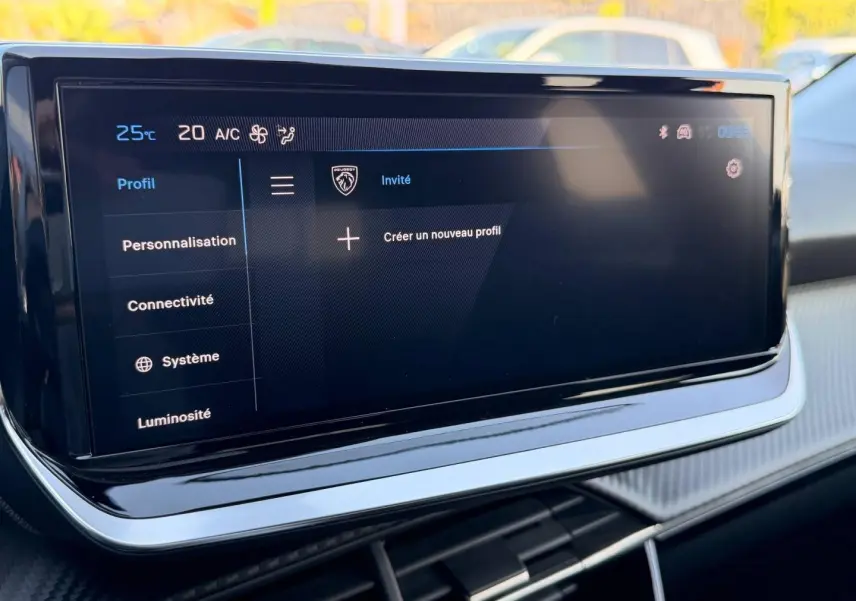 Écran tactile multifonction Peugeot 208 2025 en gros plan, affichant le menu profil sur fond noir.