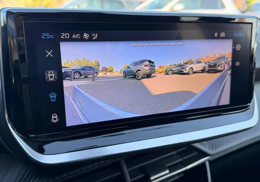 Écran tactile intérieur montrant la caméra de recul avec vue sur plusieurs véhicules en stationnement.