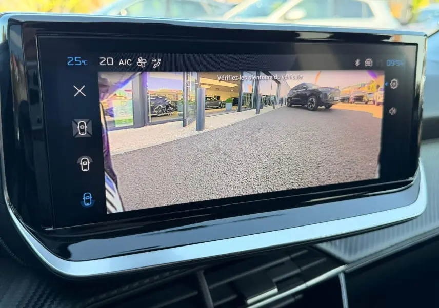 Écran tactile intérieur affichant la caméra de recul avec vue arrière sur un sol goudronné et un SUV noir.