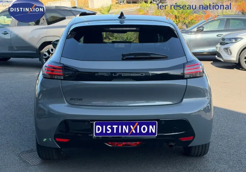 Vue arrière d'une Peugeot 208 gris Selenium avec feux arrière LED et plaque Distinxion visible en extérieur.
