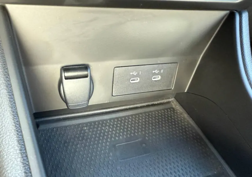 Gros plan sur la console centrale du Renault Captur 2025, montrant prises USB-C et prise 12V dans un espace noir mat.
