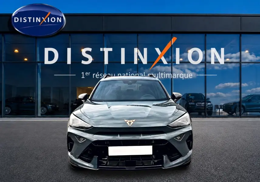 Vue frontale d'une CUPRA Formentor 1.5 etsi hybrid 150 DSG7 en bleu fjord devant une vitrine Distinxion.