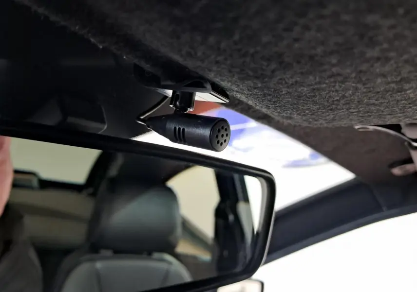Microphone fixé au plafond intérieur au-dessus du rétroviseur dans une Aixam Ambition rouge 2025.