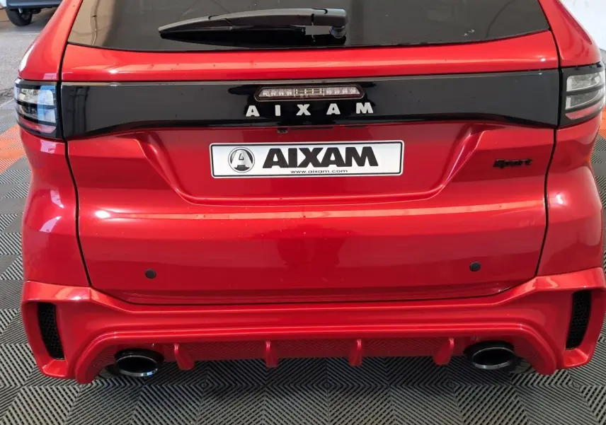 Vue arrière d'une Aixam Ambition rouge 2025 avec logo AIXAM et double sortie d'échappement intégrée au pare-chocs sport.