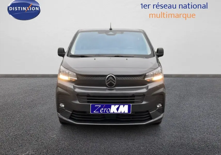 Vue frontale d'un Citroën Jumpy Cabine Approfondie gris titane métal avec feux allumés sur fond neutre.