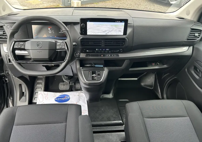 Vue intérieure avant du Citroën Jumpy cabine approfondie 2025, tableau de bord noir avec écran tactile central et volant multifonction.