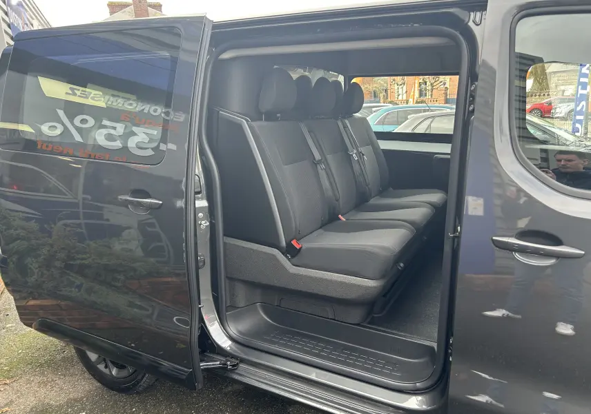 Vue latérale droite sur l'intérieur du Citroën Jumpy Long L3 gris titane, montrant la banquette arrière trois places.