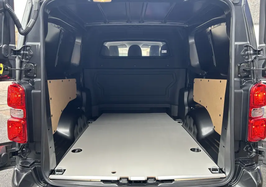 Vue arrière ouverte du Citroën Jumpy Long L3 gris titane métal, montrant l’espace de chargement vide et les panneaux latéraux en bois.