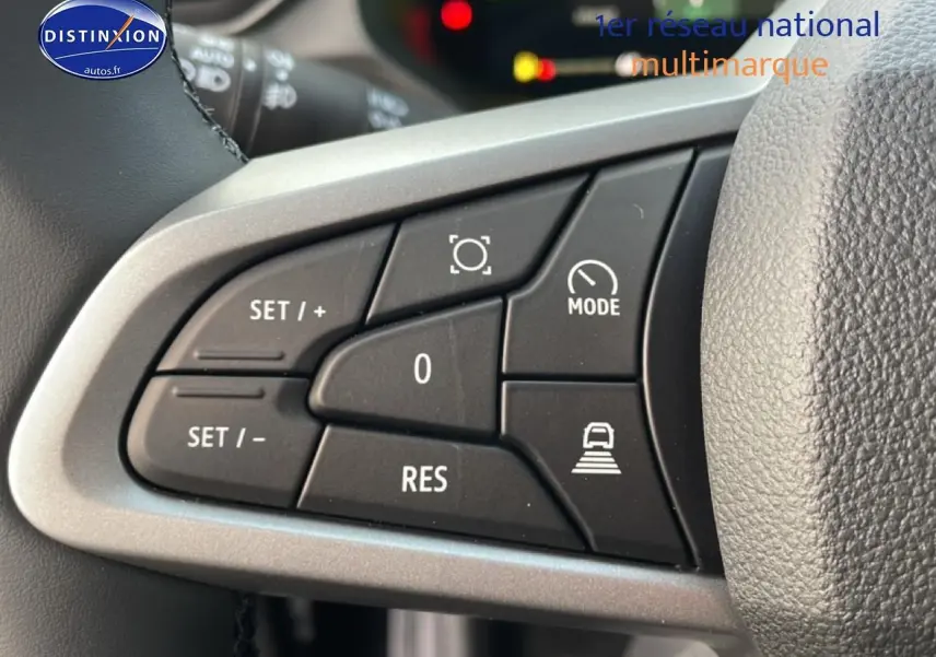 Gros plan sur les commandes au volant du Dacia Bigster 2025, boutons noirs avec cadre argenté et pictogrammes blancs.