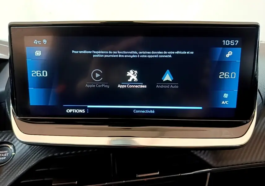 Vue intérieure centrée sur l'écran tactile 10 pouces du tableau de bord de la Peugeot 208 blanche, affichant Apple CarPlay et Android Auto.