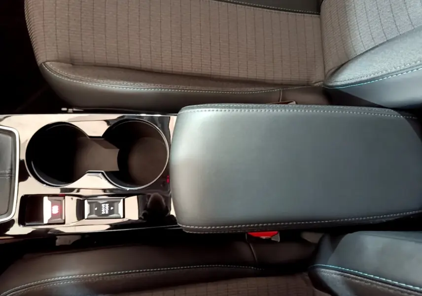 Vue rapprochée de l'accoudoir central noir et porte-gobelets de la Peugeot 208 PureTech 100 S&S Allure Business.