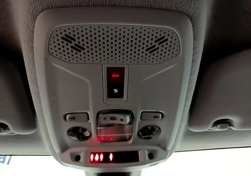 Vue intérieure du plafonnier gris avec bouton SOS rouge allumé dans une Peugeot 208 blanche de 2021.