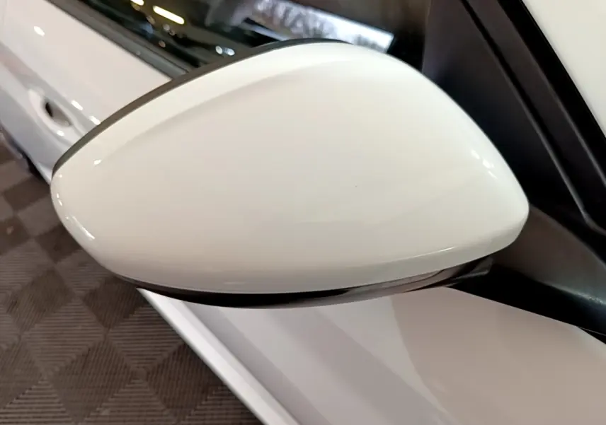 Rétroviseur blanc côté conducteur d'une Peugeot 208 PureTech 100 S&S Allure Business 2021, vue rapprochée en intérieur.