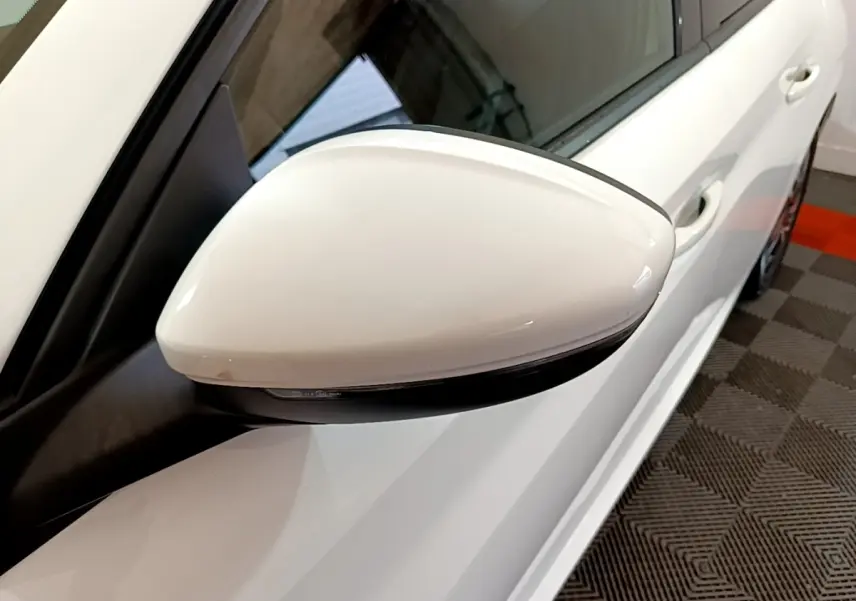 Gros plan sur le rétroviseur droit blanc d'une Peugeot 208 PureTech 100 S&S Allure Business, vue côté droit.