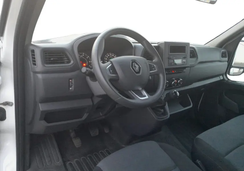 Intérieur côté conducteur du Renault Master Benne blanc 2024, tableau de bord avec volant multifonction et boîte manuelle.
