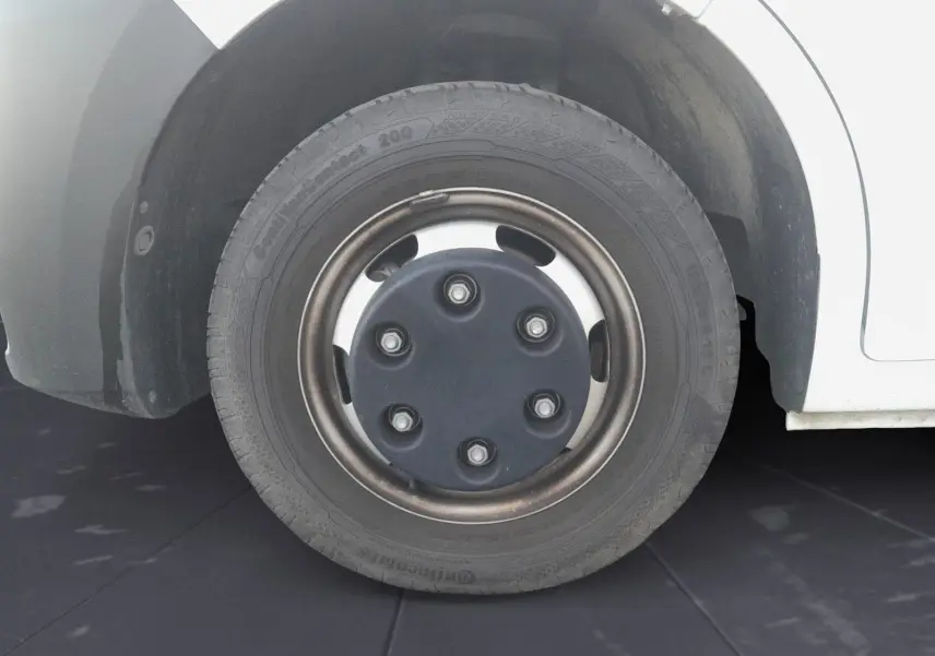 Gros plan sur la roue avant droite du Renault Master Châssis Cabine blanc avec jante acier et cache central noir.