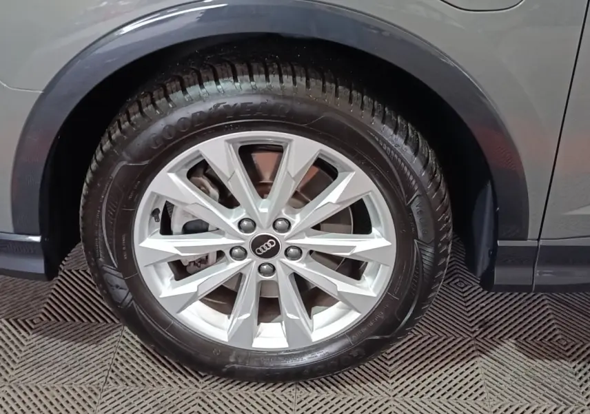 Gros plan sur la roue avant droite gris foncé d’un Audi Q3 Sportback 45 TFSI e avec jante argentée à dix branches.