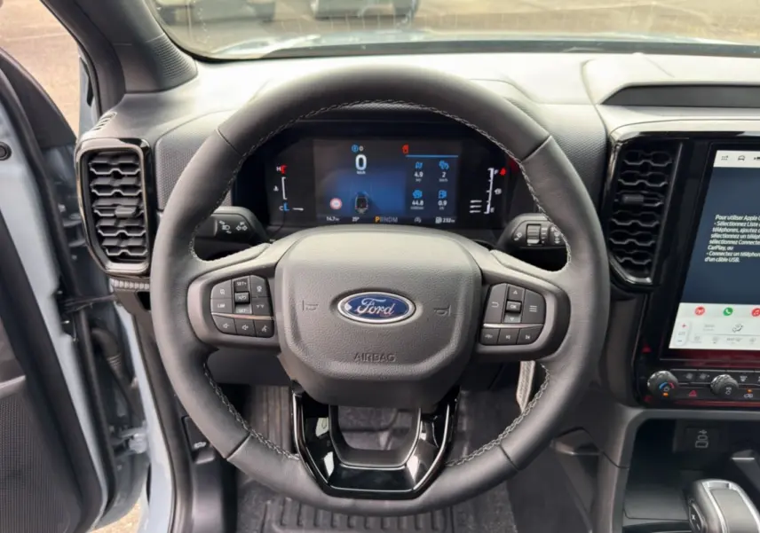 Vue centrée sur le volant cuir multifonctions et tableau de bord numérique du Ford Ranger gris commandeur 2026.