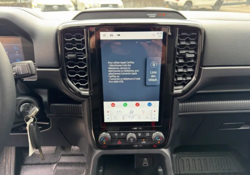 Vue rapprochée du tableau de bord du Ford Ranger 2026, avec écran tactile vertical et commandes climatisation visibles.