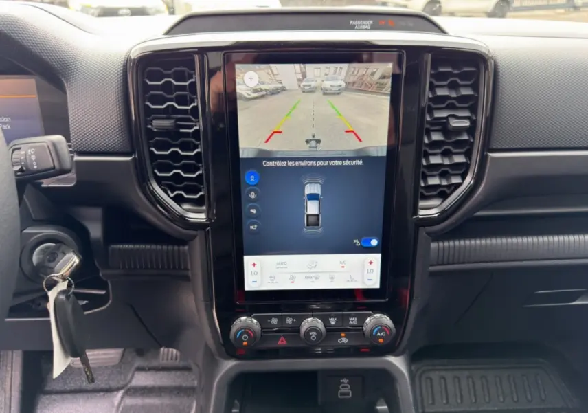 Vue rapprochée du tableau de bord noir du Ford Ranger 2026 avec écran tactile affichant la caméra de recul.