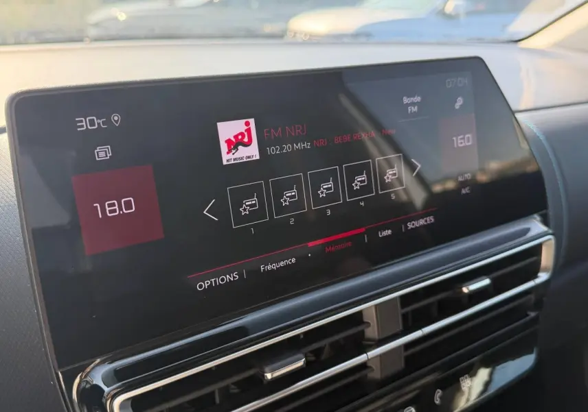 Écran tactile central affichant la radio FM NRJ dans l’habitacle du Citroën C5 Aircross blanc, vue rapprochée.