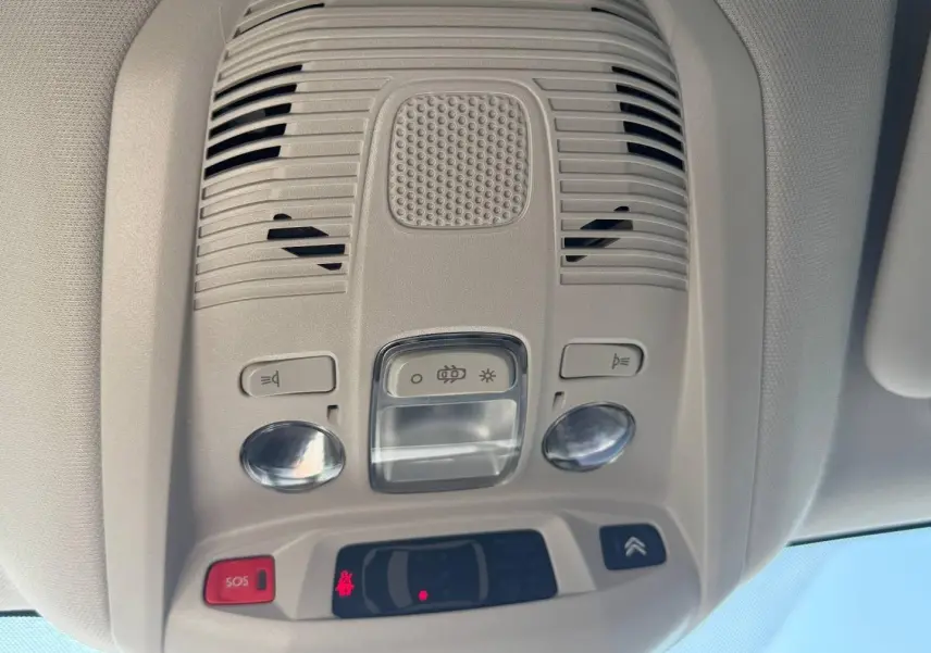 Vue intérieure du plafonnier gris clair avec commandes d’éclairage et bouton SOS du Citroën C5 Aircross blanc.