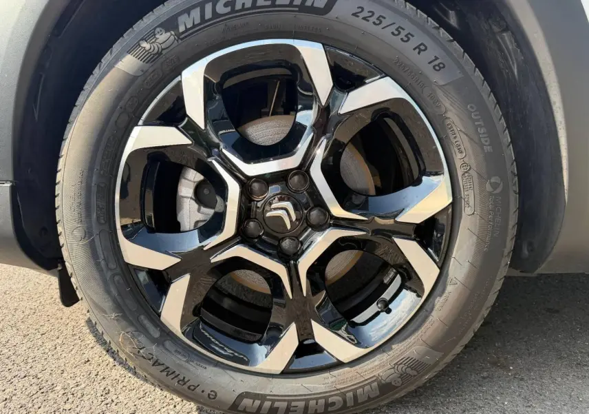 Gros plan sur la jante alu noire et argentée de 18 pouces avec logo Citroën au centre, pneu Michelin visible.