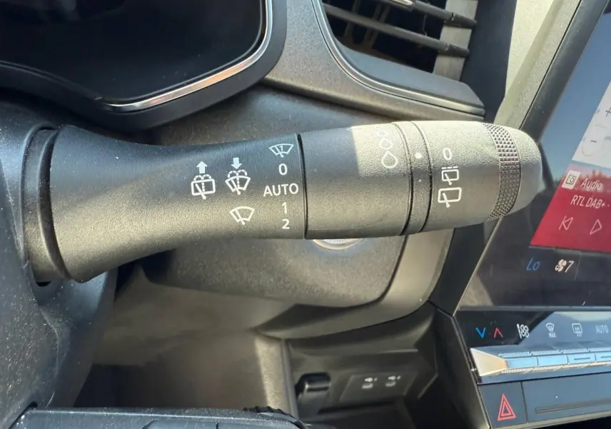 Gros plan sur la commande d'essuie-glace côté gauche du tableau de bord du Renault Captur gris Rafale 2025.
