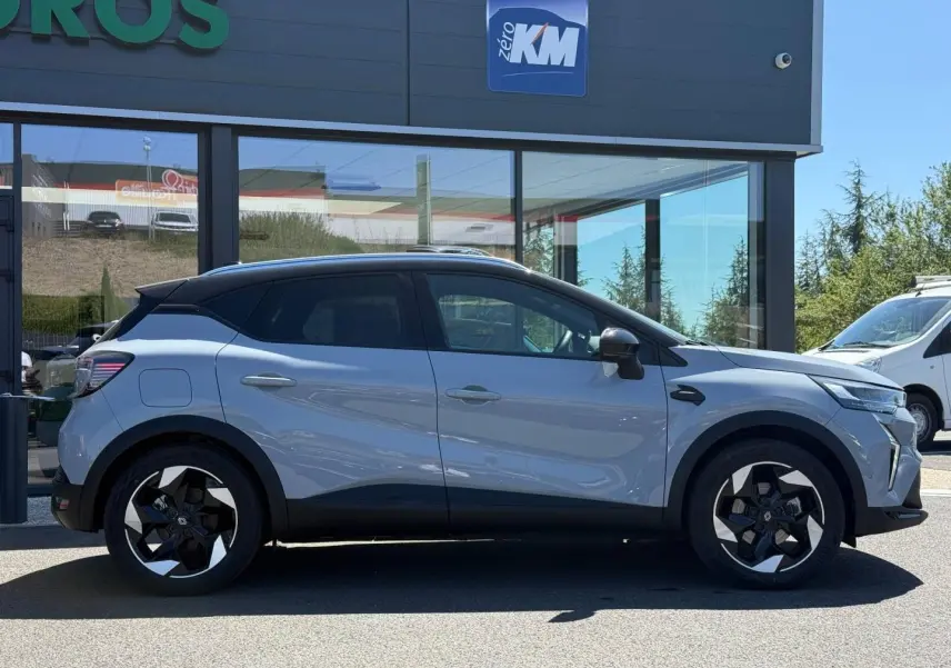 Profil droit du Renault Captur 1.6 E-Tech gris Rafale métallisé avec jantes alu noires et toit noir.
