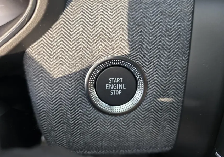 Bouton Start Engine Stop en gros plan sur console avec finition tissu gris à chevrons dans Renault Clio Gris Rafale Metal.