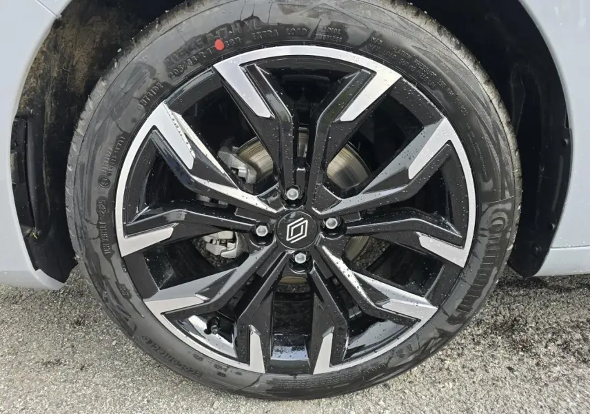 Gros plan sur la jante alliage 17 pouces noir monastella avec détails chromés du côté avant droit d'une Renault Clio gris Rafale Métal.