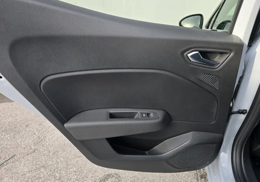 Gros plan sur la porte avant gauche intérieure noire d'une Renault Clio 2025, avec poignée argentée et commande de vitre.