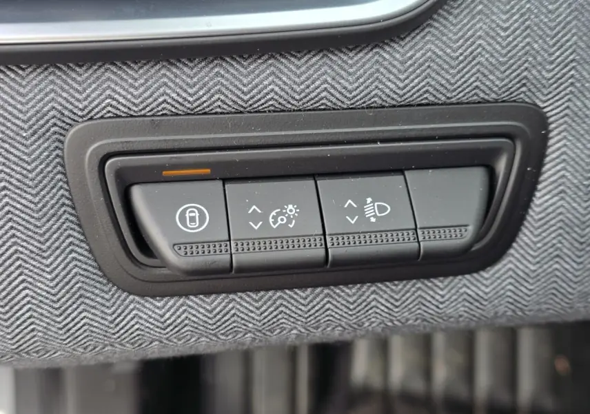 Gros plan sur les commandes d'éclairage et verrouillage sur tissu gris à chevrons dans une Renault Clio Gris Rafale Metal.