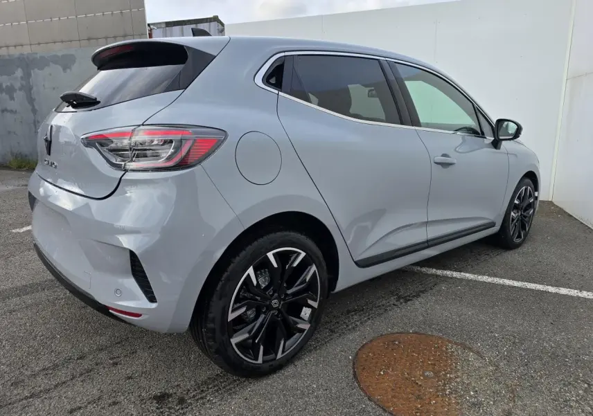 Vue 3/4 arrière droite d'une Renault Clio gris rafale métallisé avec jantes alliage noires et vitres surteintées.