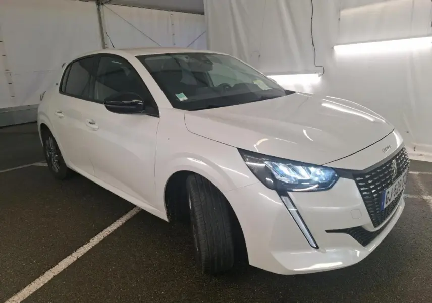 Peugeot 208 blanche vue 3/4 avant droit avec phares LED allumés et calandre noire brillante.