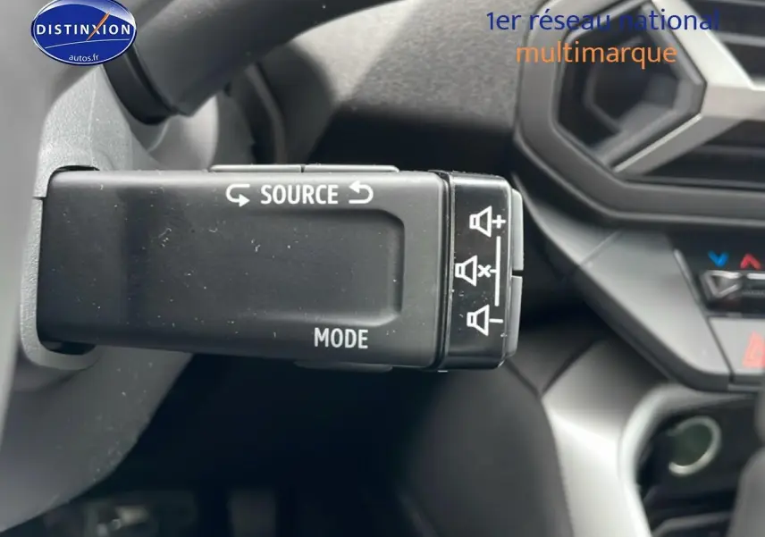 Gros plan sur la commande multimédia au volant du Dacia Bigster noir, intérieur avec tableau de bord partiel visible.