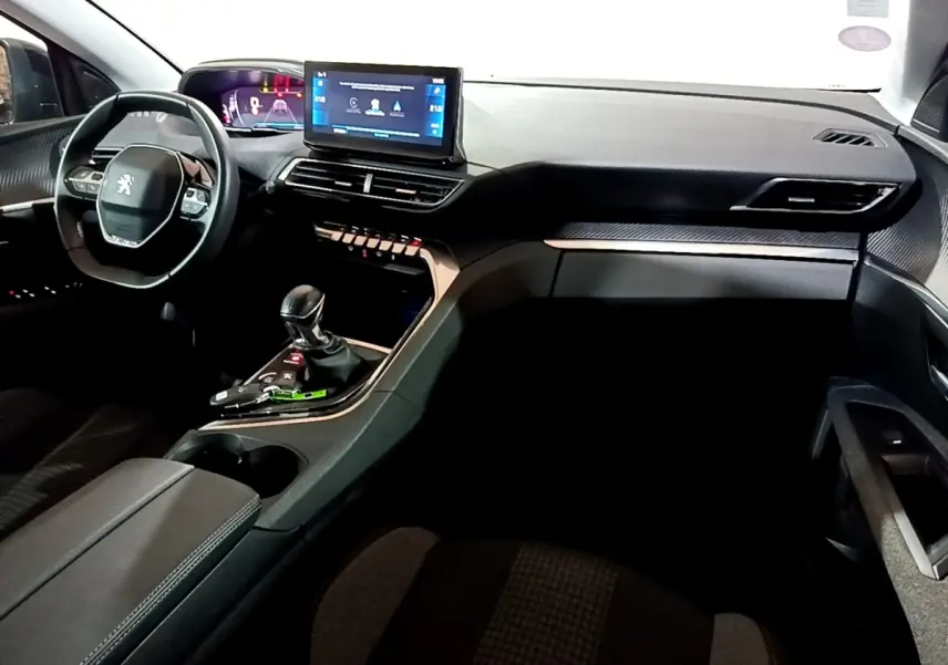 Intérieur noir du Peugeot 5008 PureTech 130, vue de face côté conducteur avec écran tactile et volant cuir multifonctions.