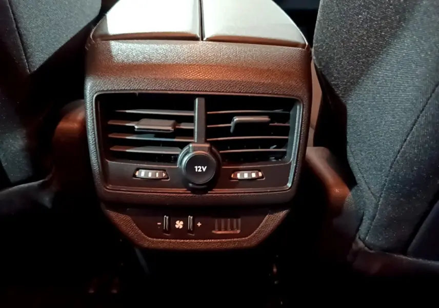 Vue rapprochée du panneau de ventilation arrière avec prise 12V et commandes de climatisation du Peugeot 5008 noir 2021.