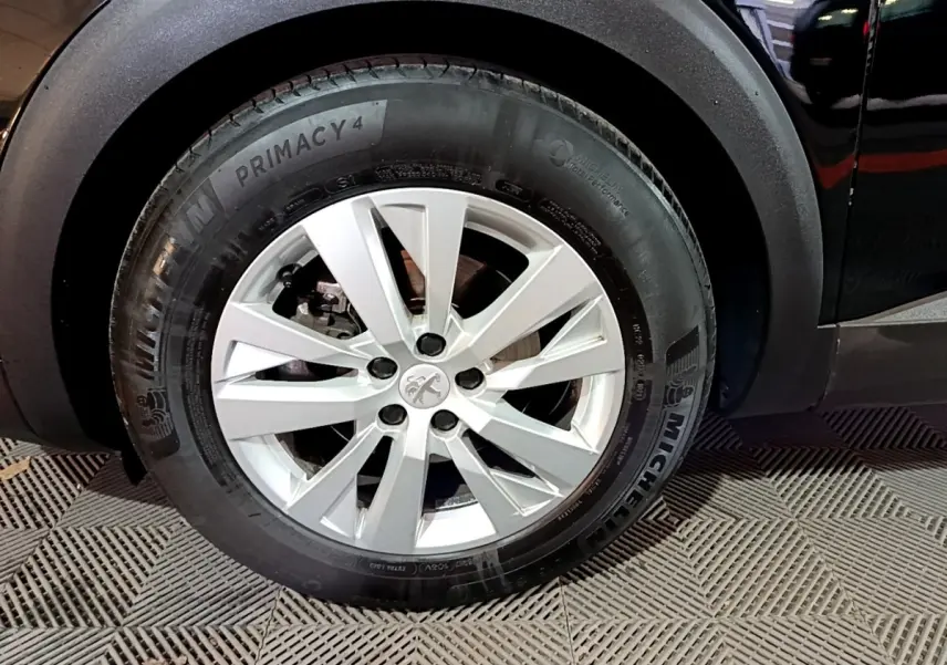 Gros plan sur la roue avant gauche du Peugeot 5008 noir, avec jante alliage et pneu Michelin Primacy 4.