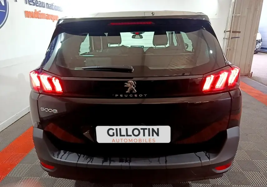 Vue arrière d’un Peugeot 5008 noir avec feux LED allumés dans un garage, plaque GILLOTIN visible.
