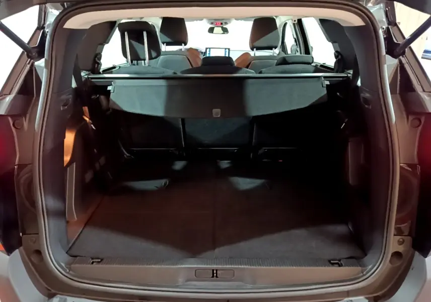 Vue arrière du coffre ouvert du Peugeot 5008 noir, montrant l'espace de chargement et la tablette cache-bagages.