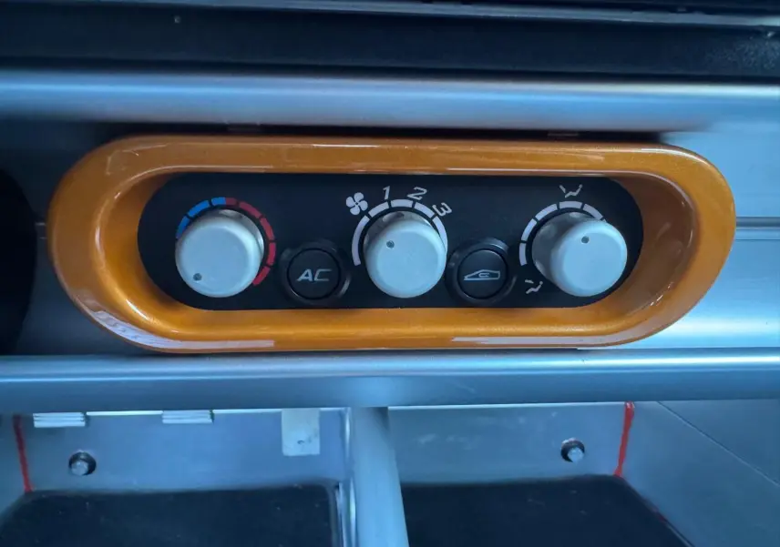 Détail de la commande de climatisation orange sur le tableau de bord de la Lotus Elise 3 Cup 250 2021.